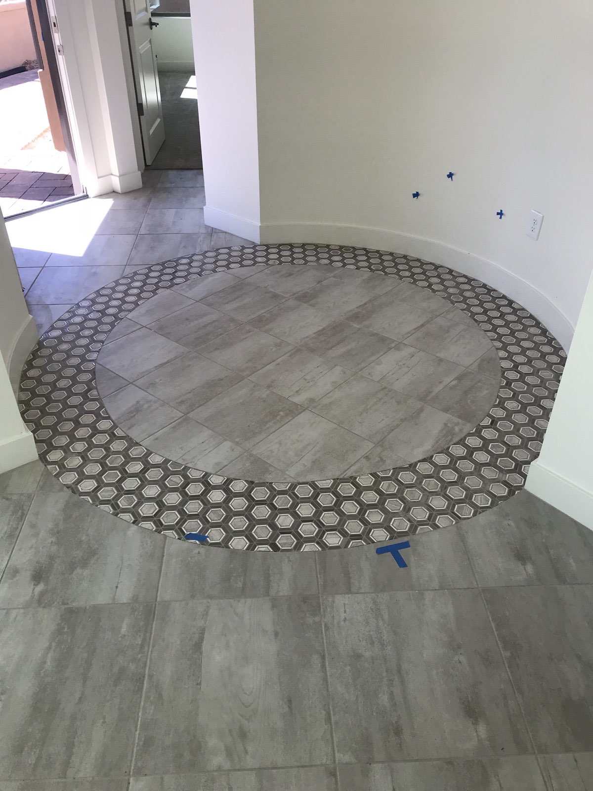 Custom tile floor with decorative circular medallion and mosaic border