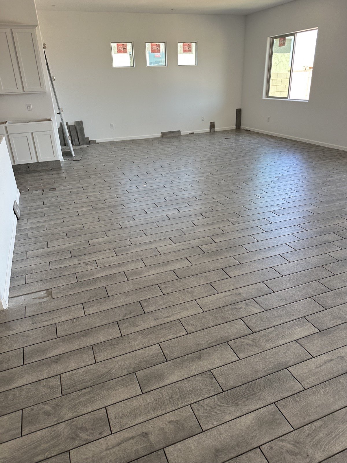 Gray wood-look tile floor at sliding glass door threshold to patio