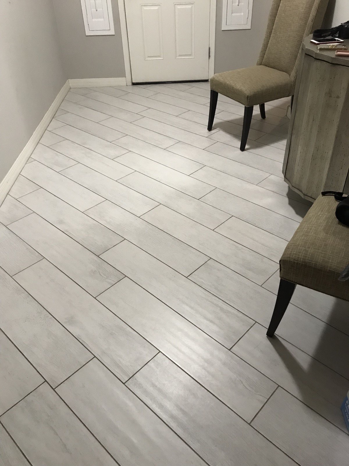 Large-format light gray tile floor in offset pattern with dark grout